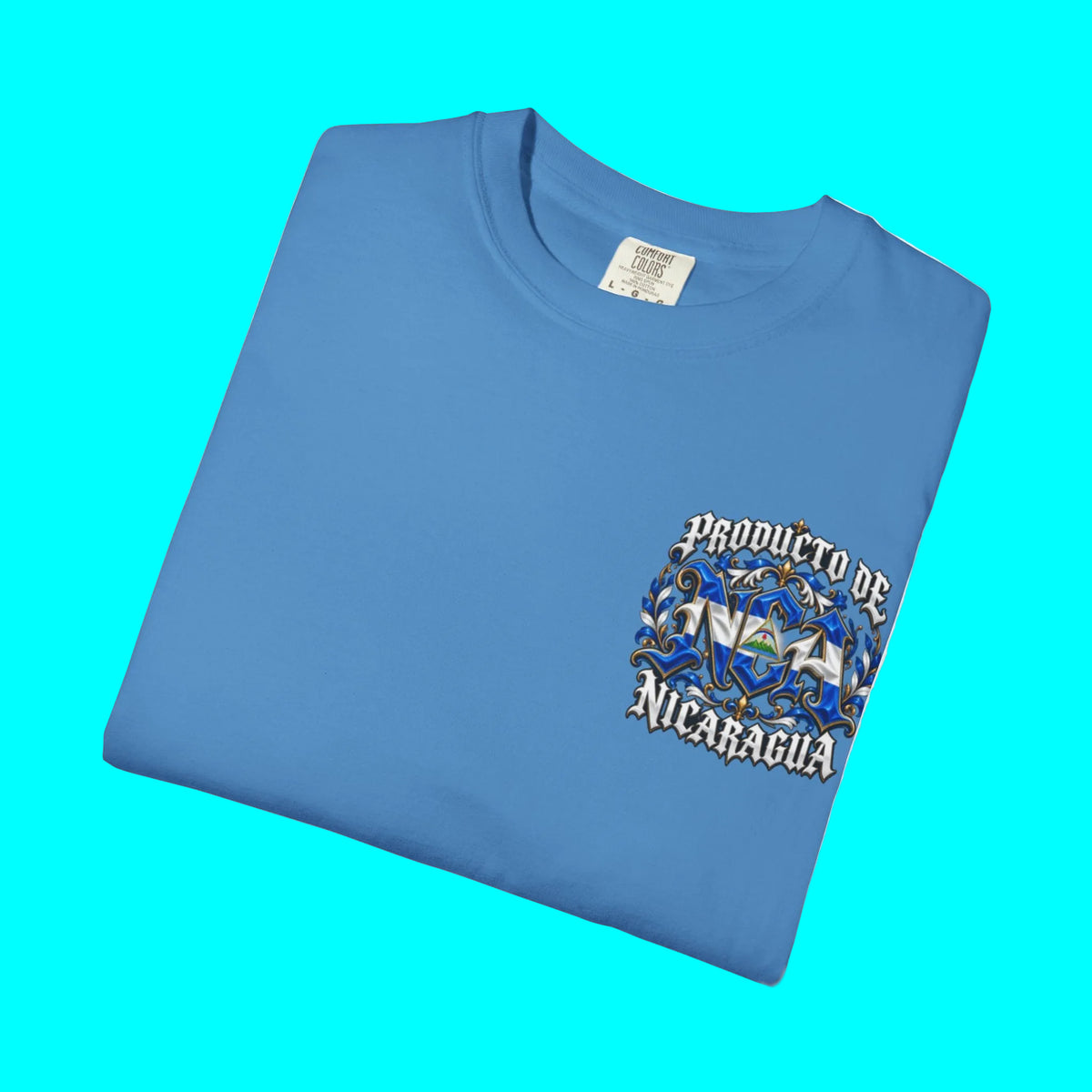 A folded light blue t-shirt with a graphic on the left chest that reads 'PRODUCTO DE LA NICAARUA' over a stylized blue and white flag design, shown on a white background.