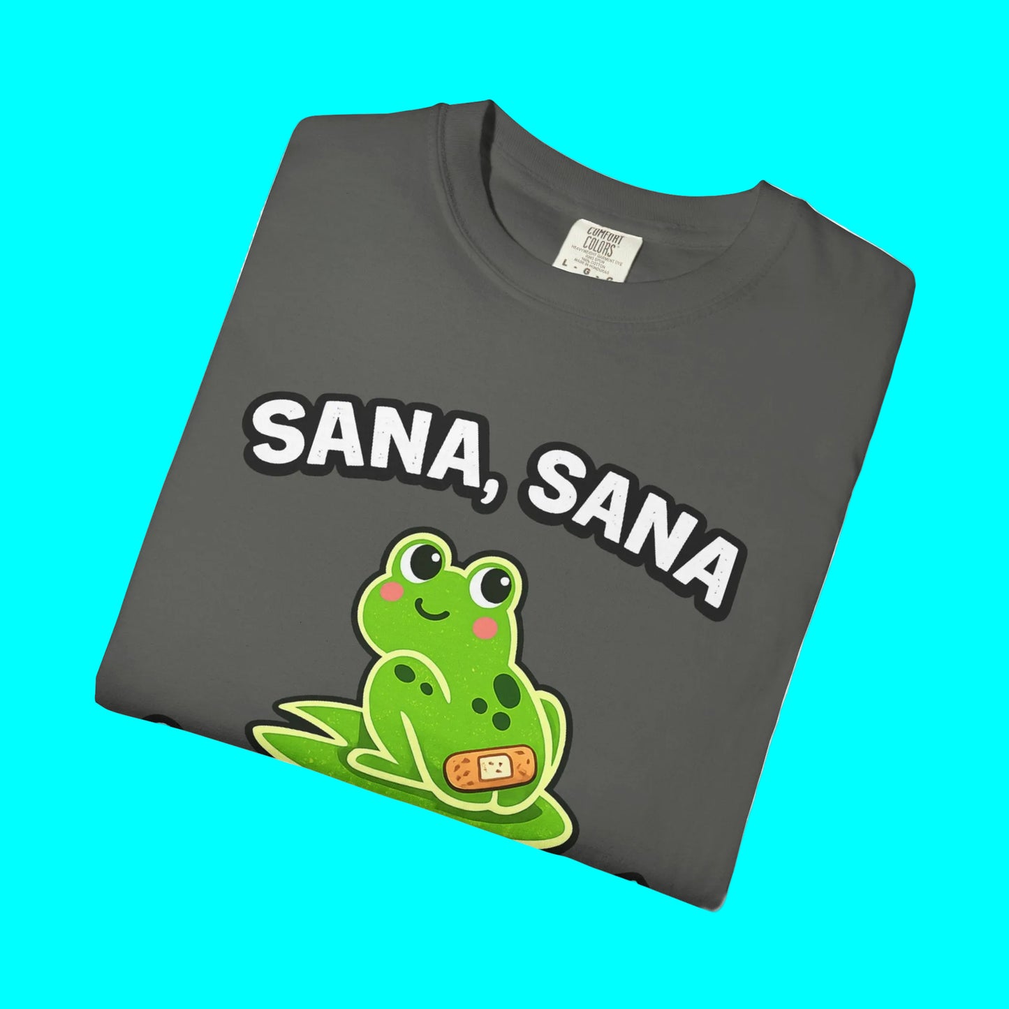 Folded gray t-shirt with a green frog graphic and 'SANA, SANA' text on a white background