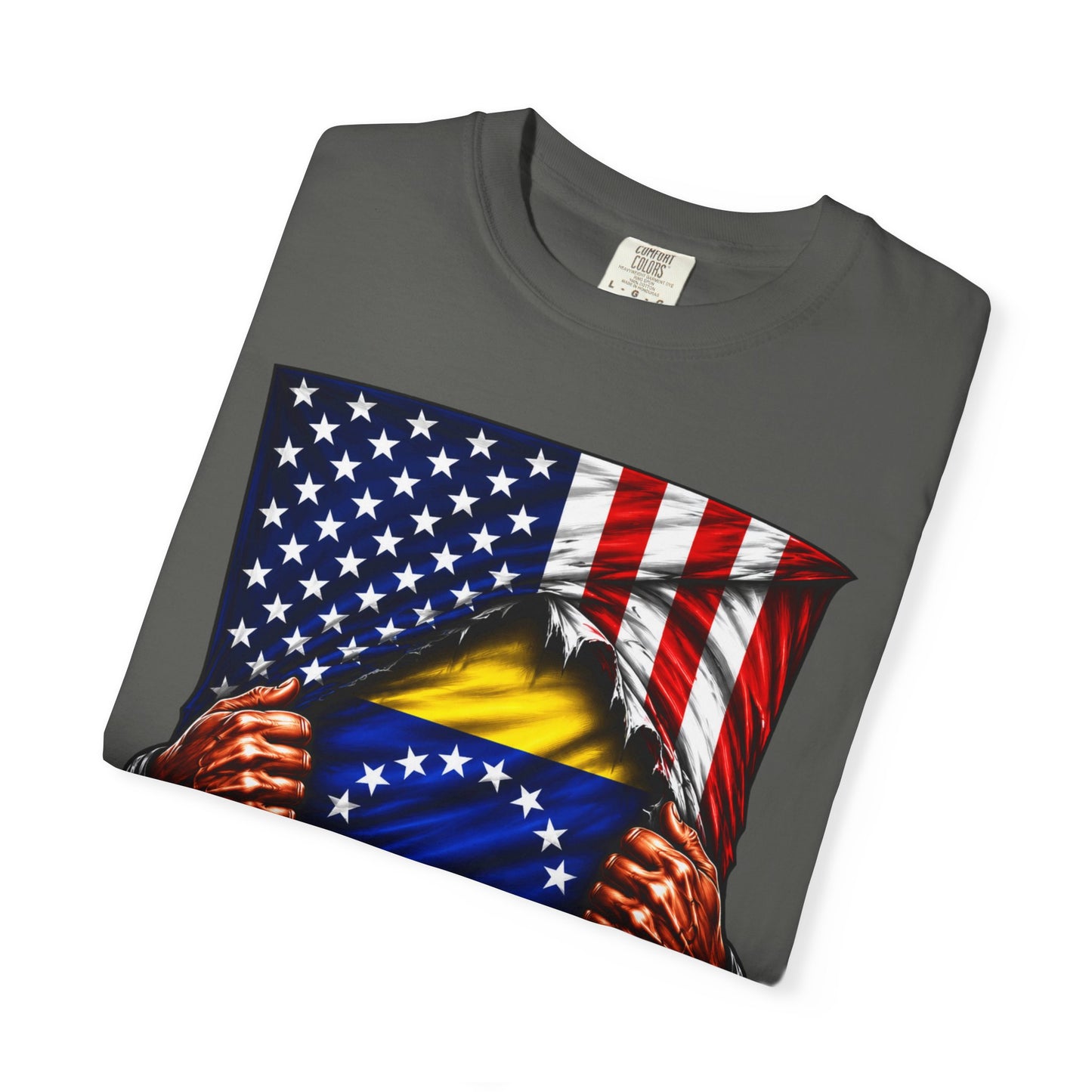 A dark gray crewneck t-shirt with a graphic print of a patriotic American flag being ripped open to reveal a yellow and blue flag underneath, with two hands tearing the fabric. The t-shirt is displayed on a clean white background.