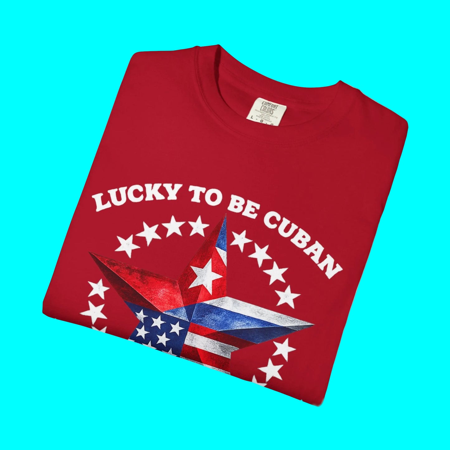 Folded red t-shirt with 'Lucky to be Cuban' text and star design on a white background