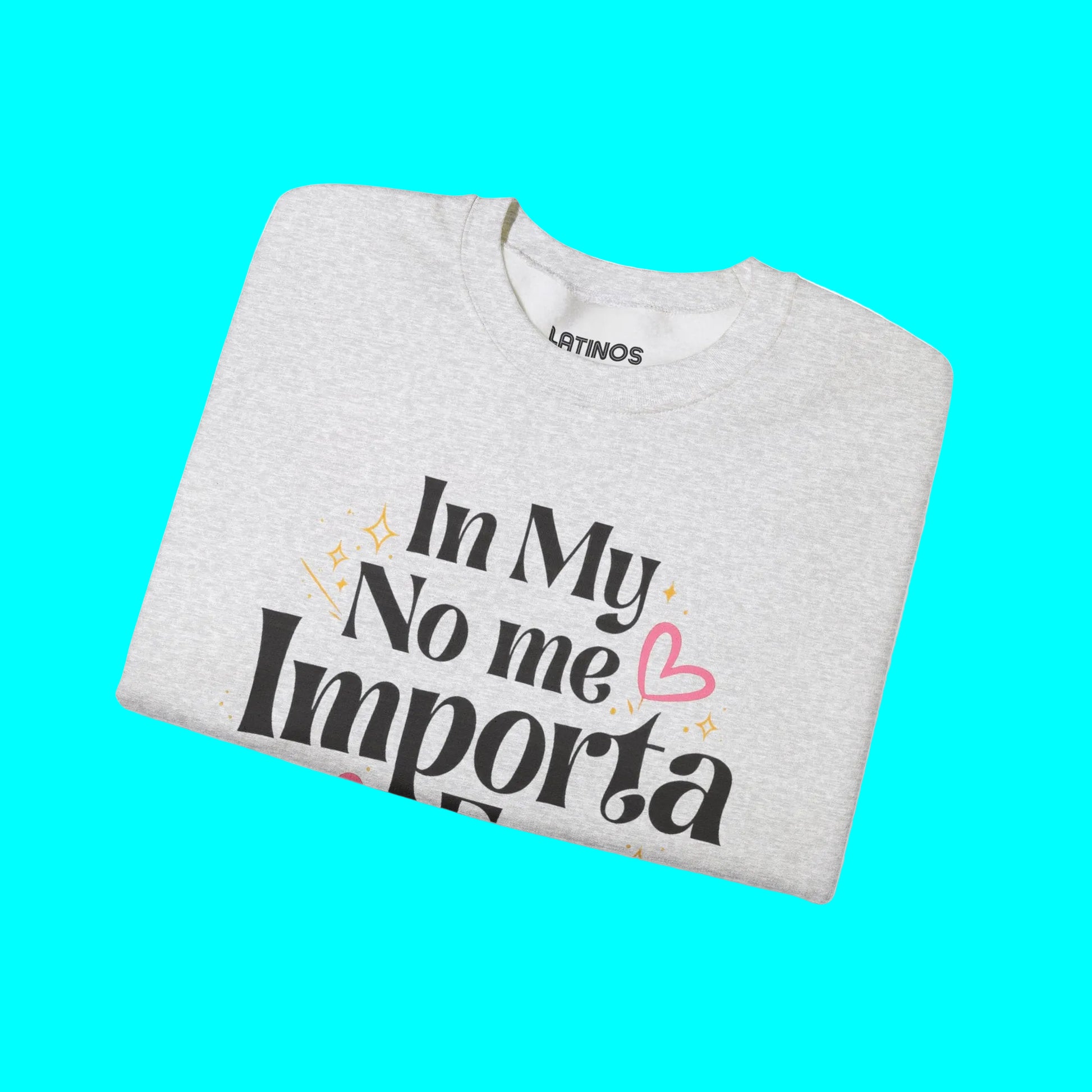 Folded gray sweatshirt with text 'In My No me Importa' on a white background