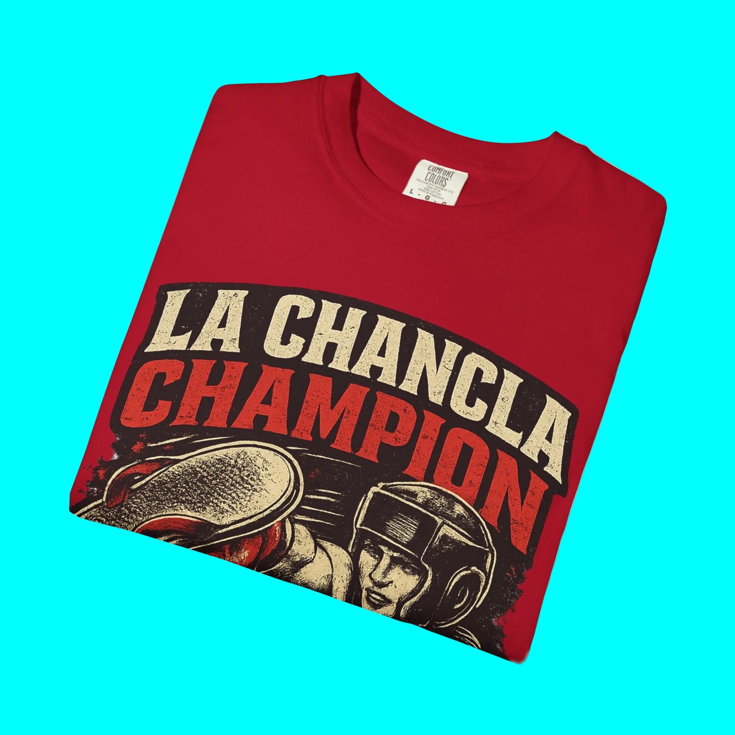 Folded red t-shirt with 'La Chancla Champion' graphic design on a white background