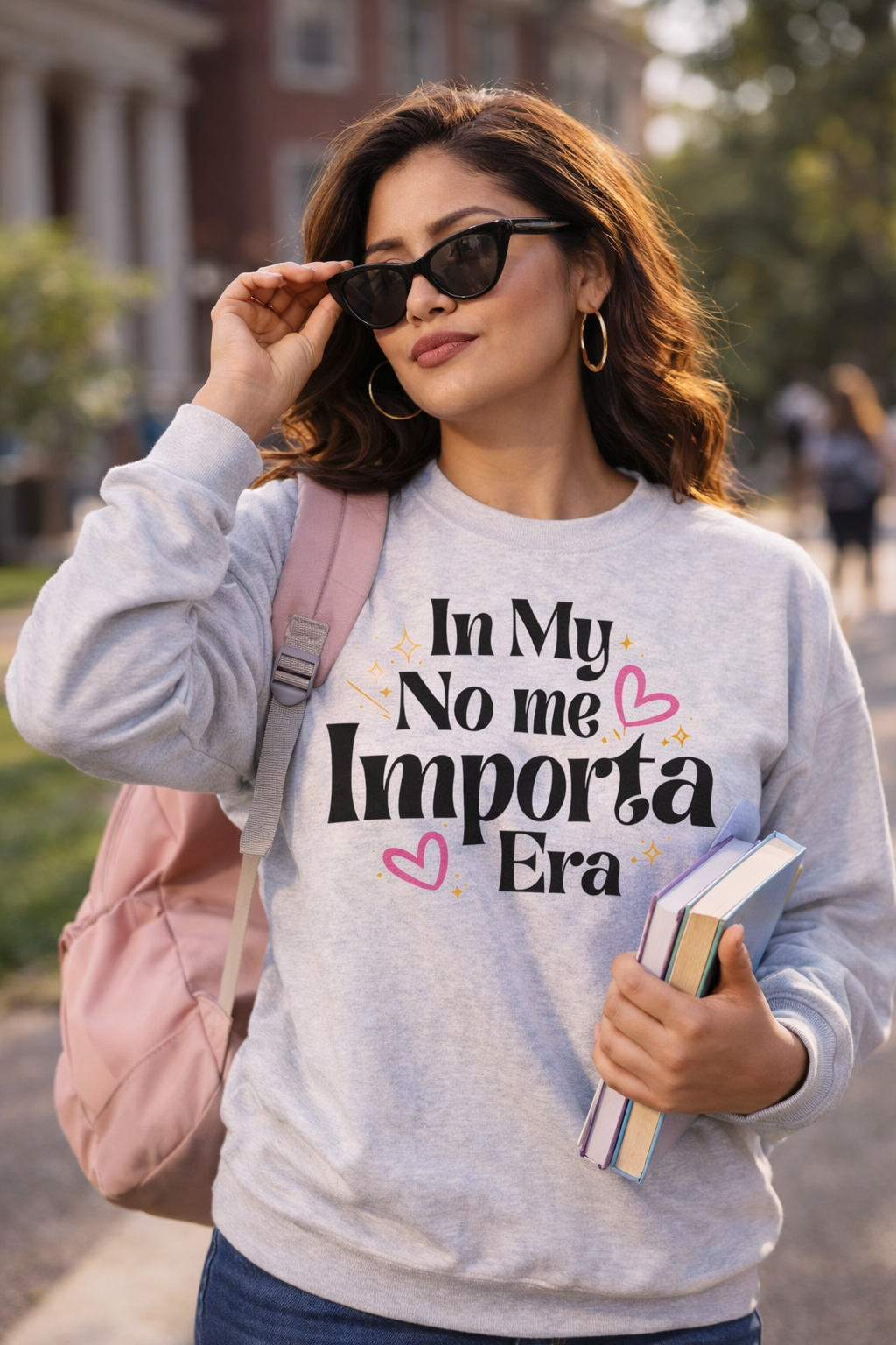 Woman wearing a sweatshirt with text and holding books outdoors