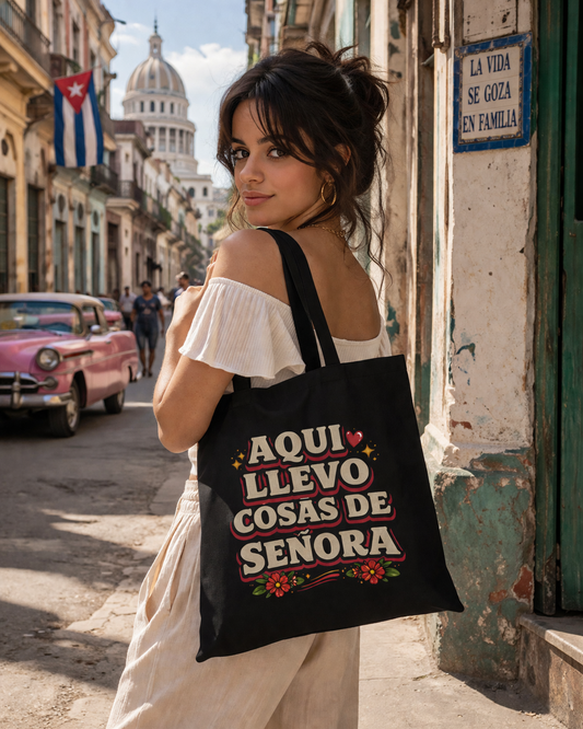 Woman holding a tote bag with text on a street in a city.