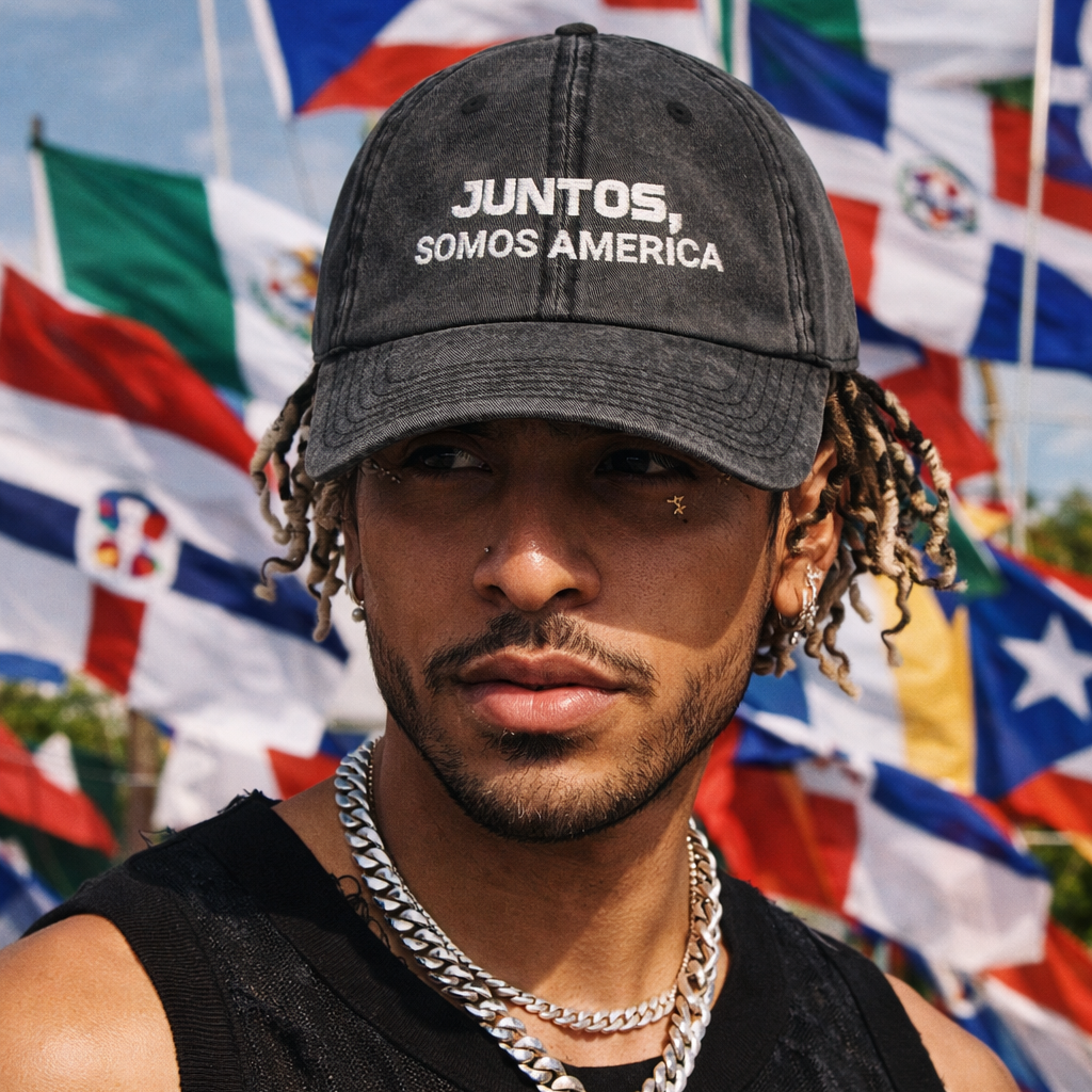 Man wearing a cap with 'Juntos, Somos America' text in front of flags