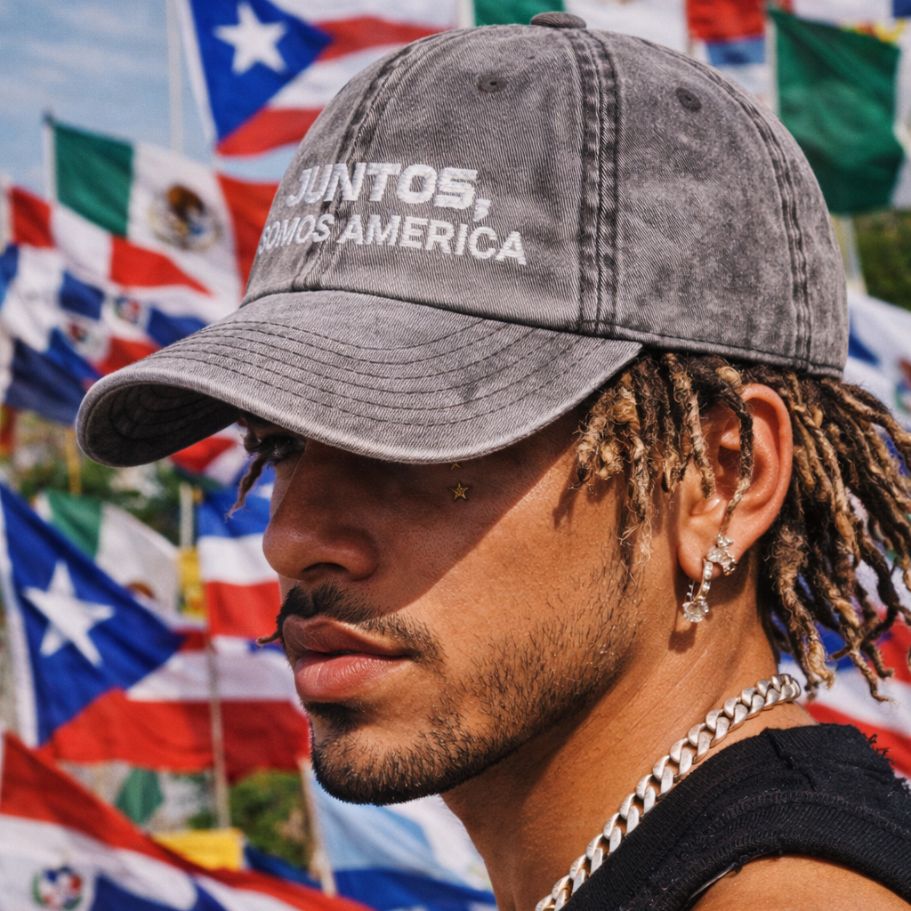 Man wearing a cap with 'Juntos, Somos America' text in front of various flags.