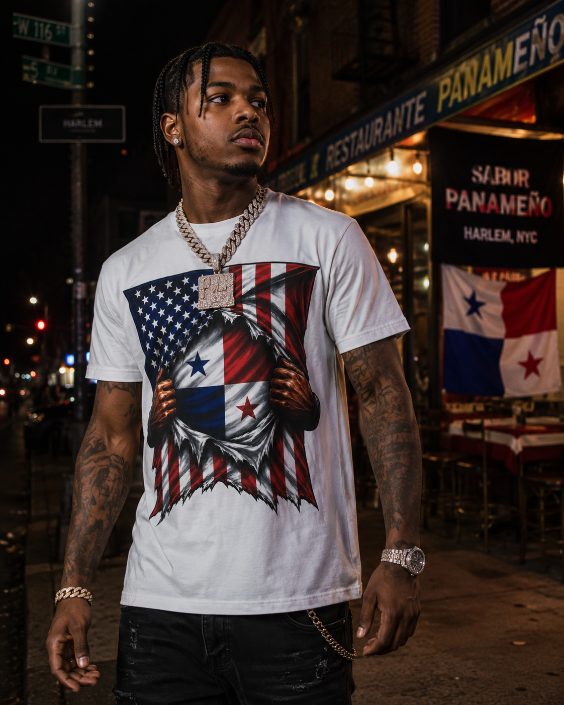 A man wearing a white graphic t-shirt with a patriotic design of a hand tearing apart an American flag to reveal the Panamanian flag underneath, set against a nighttime street scene in Harlem.