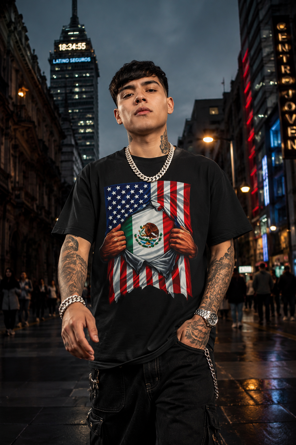 Person wearing a black t-shirt with a graphic design of an American flag and Mexican flag, standing in a city street at night.