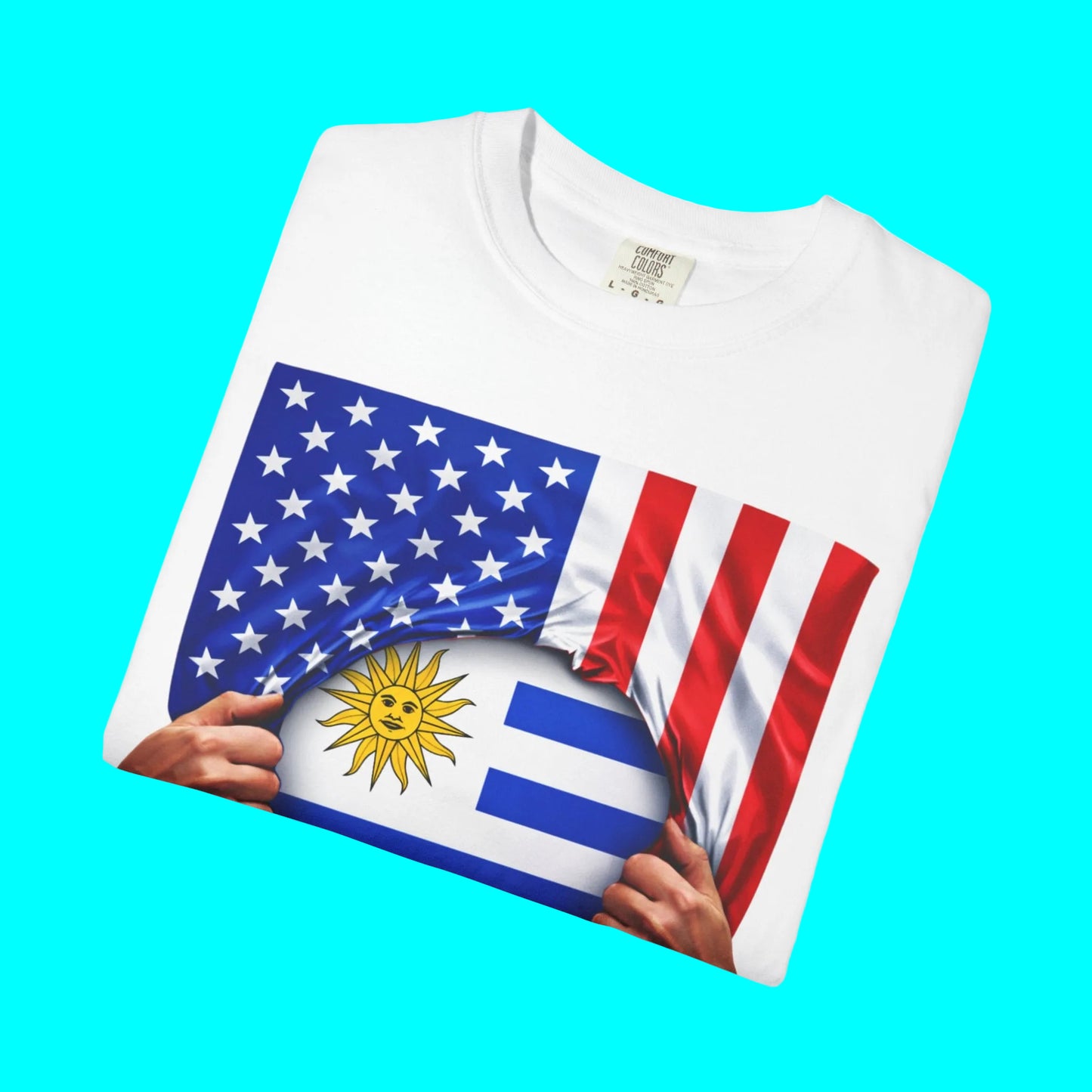 White t-shirt with a design of two flags, one American and one Uruguayan, held between two hands.