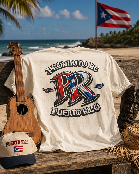 A cream-colored graphic t-shirt displayed on a rustic wooden bench at a beach, styled with a ukulele, a 'Puerto Rico' baseball cap, a carved wooden mask, and a straw hat. The background shows the ocean, palm trees, and a Puerto Rican flag.