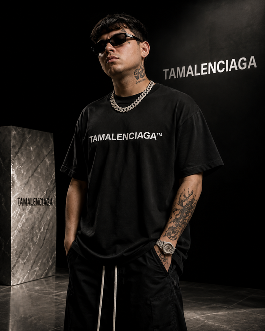 Person wearing a black 'TAMALENCIAGA' t-shirt in a branded setting